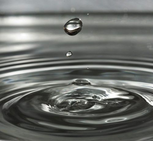 Captivating close-up shot of water droplets causing ripples, symbolizing tranquility and nature's simplicity.